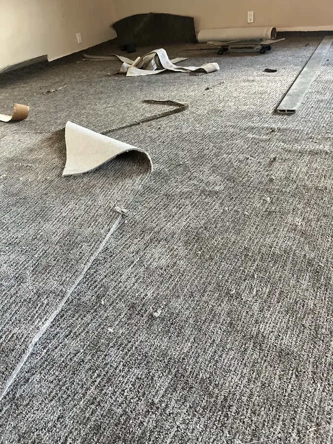 Gray patterned carpet being fitted during installation by the My-Key crew